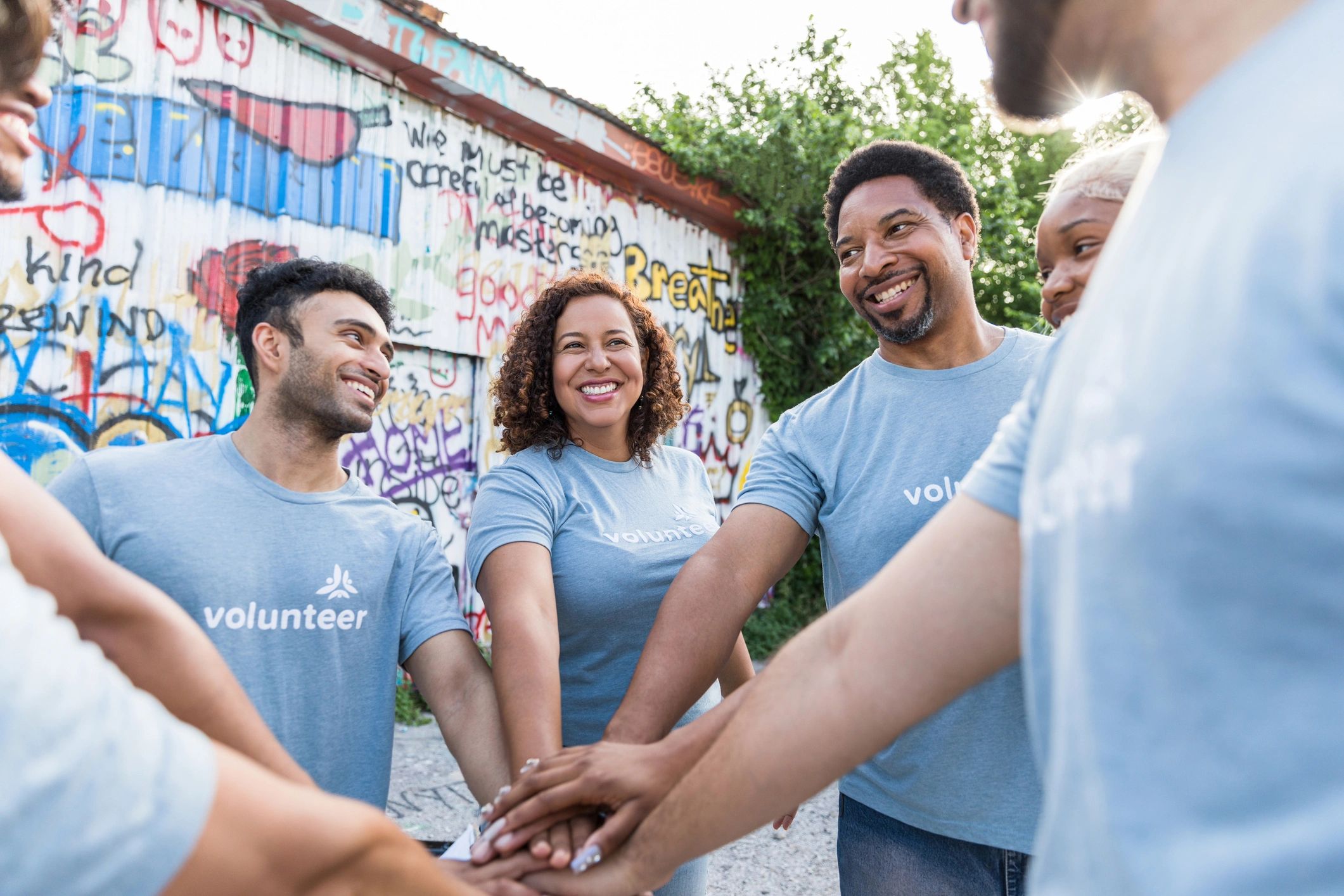 Volunteers with hands together showing community support