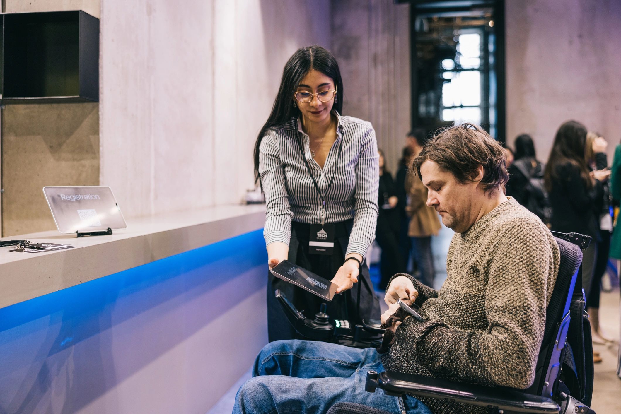 Conference staff assisting an attendee using a wheelchair