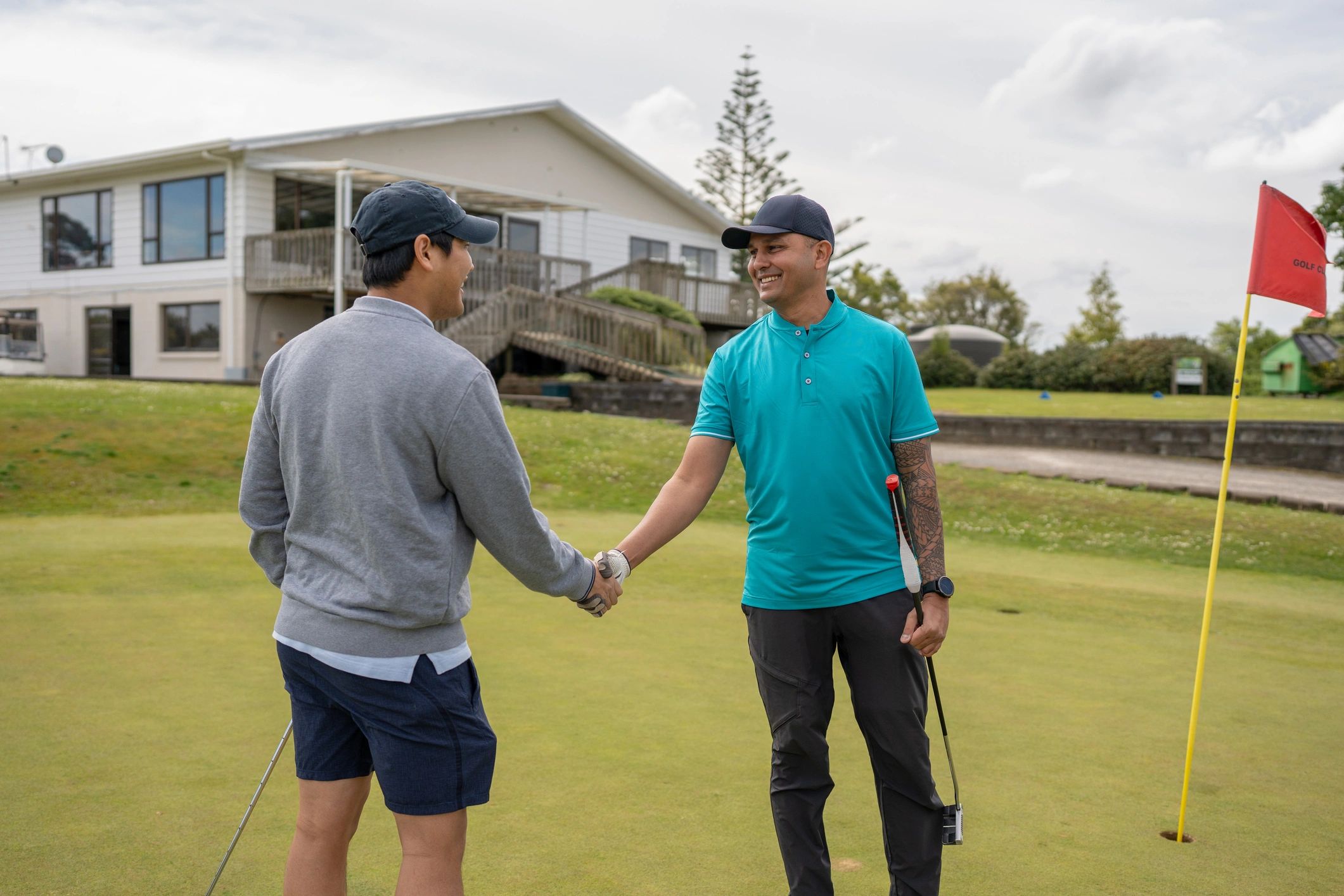 Two golfers shaking hands on the green