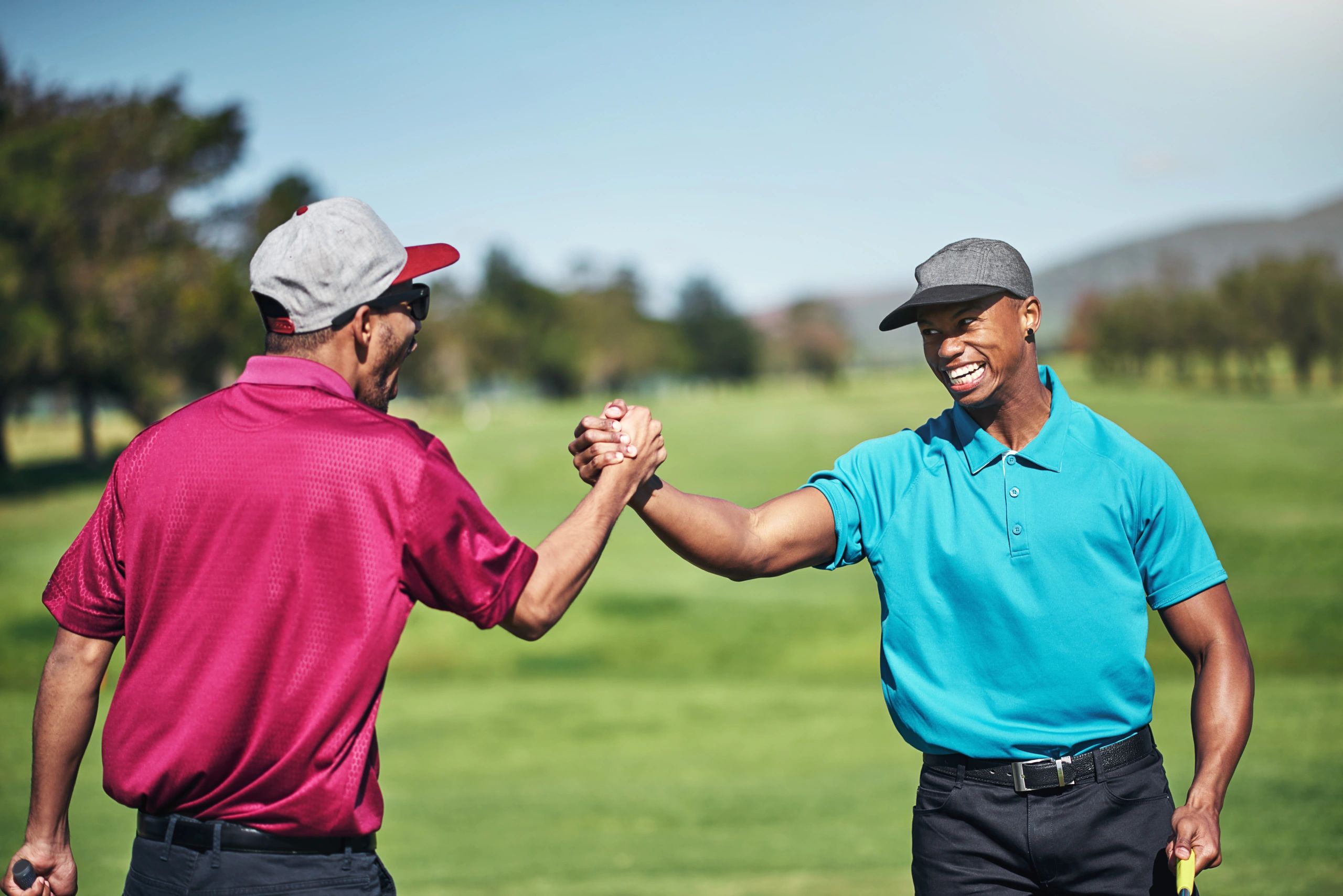 Two golfers shaking hands on a golf course